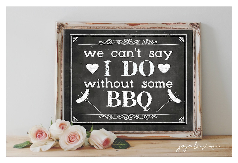 May include: A white sign with black text on a chalkboard background. The sign reads "We can't say I DO without some BBQ."  The sign is framed in a rustic white frame.