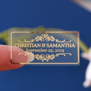 Pequeñas etiquetas adhesivas personalizadas rectangulares para bodas, ideales para recuerdos. Vinilo transparente, blanco e impermeable con detalles dorados.