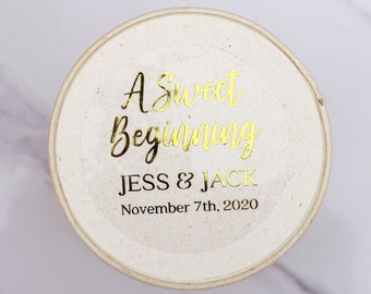 May include: A white round sticker with gold lettering that says "A Sweet Beginning Jess & Jack November 7th, 2020".