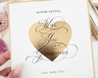May include: A white card with gold trim and a gold foil heart that says "Will you be my Godmother?" with the text "Auntie Alyssa" at the top and "Love, baby Giles" at the bottom.
