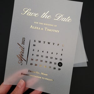May include: A save the date card with a gold foil design. The card features a calendar with the date April 22, 2023 highlighted. The text "Save the Date" and "For the Wedding of Alexa & Timothy" is also in gold foil.
