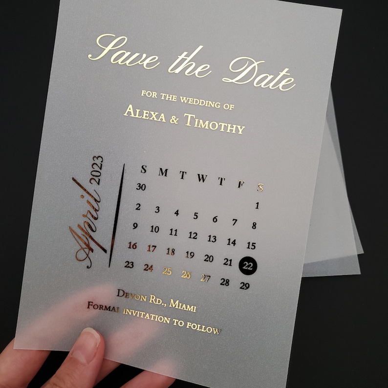 May include: A save the date card with a gold foil design. The card features a calendar with the date April 22, 2023 highlighted. The text "Save the Date" and "For the Wedding of Alexa & Timothy" is also in gold foil.