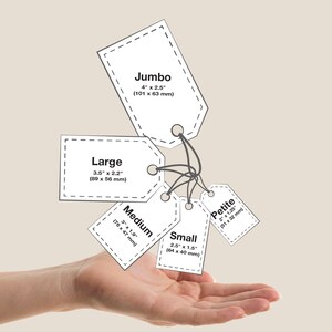 Pu&ograve; includere: Un set di cinque etichette rettangolari in carta bianca con angoli superiori arrotondati, ciascuna fissata con un cordino nero. Le etichette riportano le scritte Jumbo 101 x 63 mm, Large 89 x 56 mm, Medium 76 x 47 mm, Small 64 x 40 mm e Petite 51 x 32 mm.