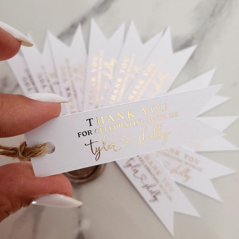XOXOKristen gold foil Heart Connected Wedding Favor Tags featuring “Thank you for celebrating with us” and connected names with a heart symbol, printed on crisp white card — perfect for elegant wedding favors.