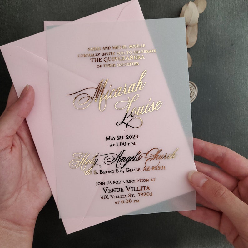 XOXOKristen gold foil Quinceañera invitation on frosted acrylic, photographed beside soft dried flowers and natural stones under warm sunlight, showcasing luxury design for personalized 15th birthday parties – XOXOKristen.