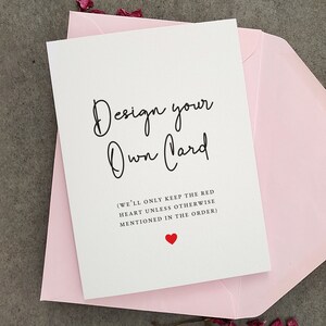 May include: A white card with black text that says "Design your Own Card" and "(WE'LL ONLY KEEP THE RED HEART UNLESS OTHERWISE MENTIONED IN THE ORDER)". A small red heart is at the bottom of the card.