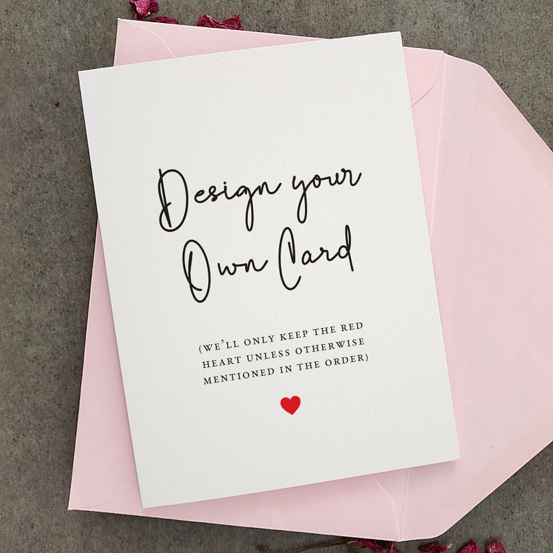 May include: A white card with black text that says "Design your Own Card" and "(WE'LL ONLY KEEP THE RED HEART UNLESS OTHERWISE MENTIONED IN THE ORDER)". A small red heart is at the bottom of the card.