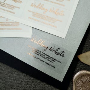 Transparent sticker with gold foiled text print.  Wedding Website is written at the top. Below the text reads: visit our website for venue information, accommodation, activities, and more wedding details. At the bottom is your wedding website link.