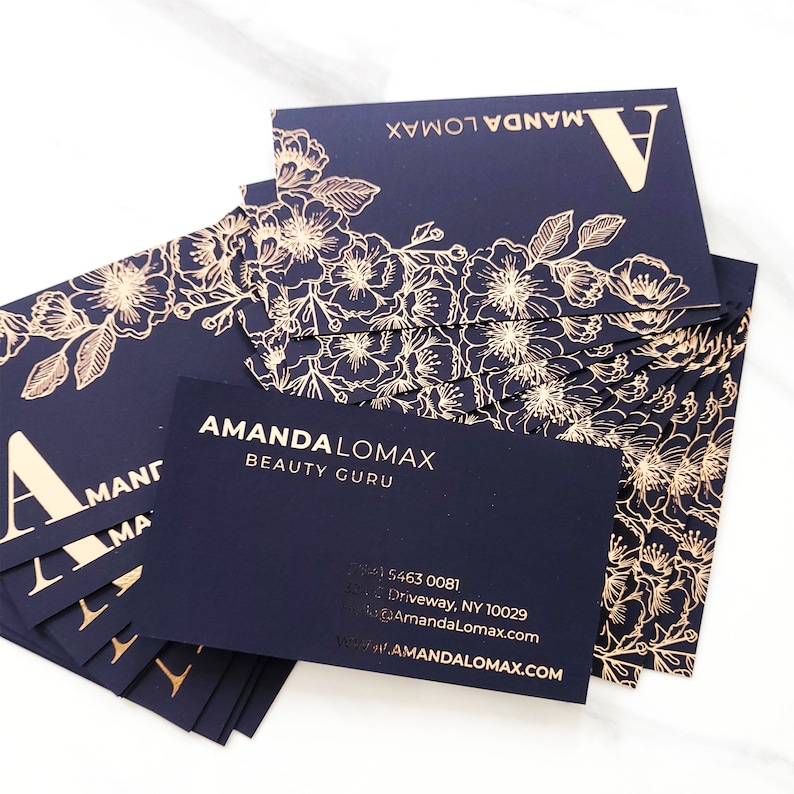 Black velvet business cards with a gold foil print. The design features gold floral decoration as a background. At the bottom in gold foiled print is written your name or business name. At the back the card is black with your personal details in gold