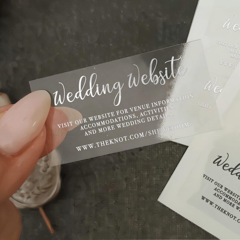 A hand holding a transparent business card with text on it.