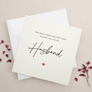 Puede incluir: Una tarjeta blanca con texto negro que dice "Lo &uacute;nico mejor que tenerte como mi esposo." Un peque&ntilde;o coraz&oacute;n rojo est&aacute; debajo del texto.