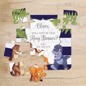 Könnte beinhalten: Ein individuelles Puzzle mit einem marineblau-weiß gestreiften Hintergrund. Die Puzzleteile zeigen Dinosaurier-Illustrationen und den Text "Oliver, will you be our Ring Bearer? Love, Mia and Don."