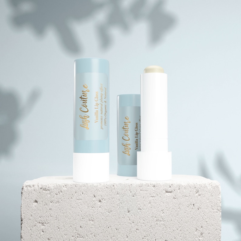 Puede incluir: Dos tubos de brillo labial de vainilla, uno con una etiqueta azul que dice "Lish Couture Brillo labial de vainilla promueve un efecto de relleno natural 100% org&aacute;nico y natural" y el otro con una etiqueta blanca que dice "Lish Couture Brillo labial de vainilla".