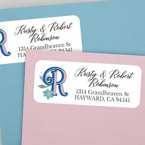 May include: Two white return address labels with a blue and pink floral initial "R" design. The labels include the text "Kristy & Robert Robinson" and the address "1314 Grandheaven St HAYWARD, CA 94541".