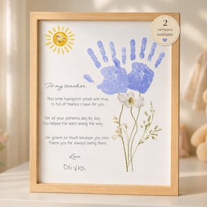 Può includere: Una stampa incorniciata con una cornice in legno chiaro. L'opera presenta un'impronta blu, un sole giallo sorridente e illustrazioni floreali. Il testo recita "Al mio insegnante" e un messaggio di ringraziamento, firmato "Olivia".