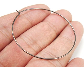 May include: A simple black hoop earring. The earring is made of thin metal and is circular in shape.