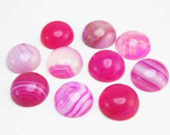 Könnte beinhalten: Sortiment von zehn rosafarbenen und weißen Achat-Cabochons. Die Cabochons sind rund und haben eine glatte, polierte Oberfläche. Sie sind perfekt für die Schmuckherstellung oder andere Bastelprojekte.