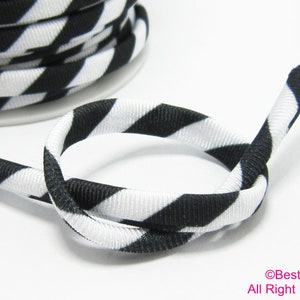 Puede incluir: Cordón elástico de rayas blancas y negras. El cordón está hecho de un material suave y elástico, ideal para manualidades, costura y otros proyectos.