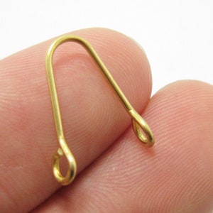 May include: Gold-toned metal jewelry finding with a loop on each end. The finding is shaped like an upside-down U.