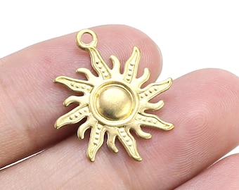 May include: Gold-toned metal sun charm pendant with a detailed design. The sun has a raised center and rays extending outward.