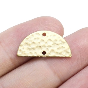 May include: Gold-toned metal half-circle charm with a hammered texture and two holes.