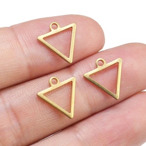 May include: Three gold triangle shaped metal charms with a loop at the top for attaching to jewellery or other crafts.