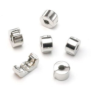 Può includere: Sei tappi per perline in metallo argentato per la creazione di gioielli. I tappi sono rotondi con una piccola apertura al centro.