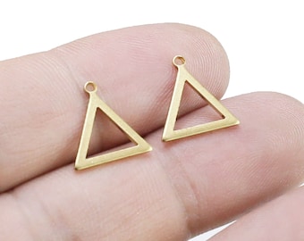 Könnte beinhalten: Zwei kleine, goldfarbene Dreiecksanhänger mit einer kleinen Schlaufe oben zur Befestigung an Schmuck. Die Anhänger werden vor einem weißen Hintergrund präsentiert, was darauf hindeutet, dass sie für Bastelarbeiten oder die Schmuckherstellung bestimmt sind.
