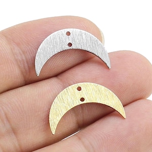 Peut inclure: Deux breloques en forme de croissant de lune. L'une est de couleur argentée avec une texture brossée, l'autre est dorée avec une texture brossée. Chaque breloque a deux petits trous pour l'enfilage.