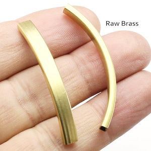 Puede incluir: Dos piezas de latón en bruto, cada una doblada en forma de curva. El latón es de color dorado brillante.