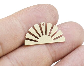 May include: A gold-colored, half-circle pendant with a sunburst design. The pendant has a small hole at the top for stringing. The sunburst design features evenly spaced rays emanating from a central curved base. This jewelry component is ideal for crafting.