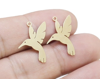 May include: Two gold-colored hummingbird charms with a jump ring for attaching to jewelry or other crafts.
