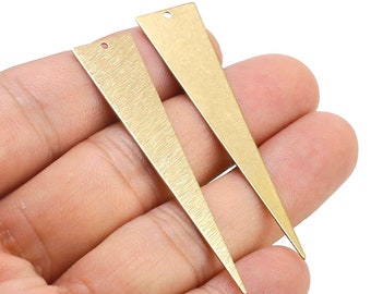 May include: Two gold-colored metal triangle shapes with a hole at the top. The triangles are brushed and have a matte finish.