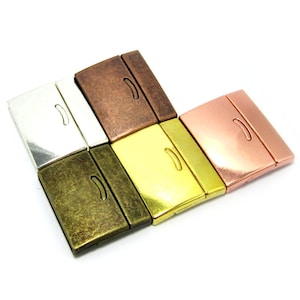 Könnte beinhalten: Sechs Magnetverschlüsse in verschiedenen Ausführungen: Silber, Kupfer, Messing, Antikmessing, Gold und Roségold. Jeder Verschluss ist rechteckig mit einer abgerundeten Kante und einer kleinen Rille.