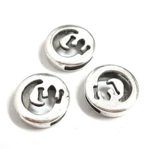 May include: Three silver-toned metal beads with a cutout design of a stylised letter 'G'.