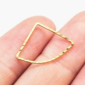 May include: Gold-toned metal ring with a textured, slightly rounded, rectangular shape.