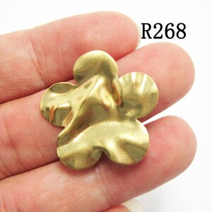 K&ouml;nnte beinhalten: Goldfarbener Metall-Blumenanh&auml;nger mit texturierter, wellenf&ouml;rmiger Oberfl&auml;che. R268.
