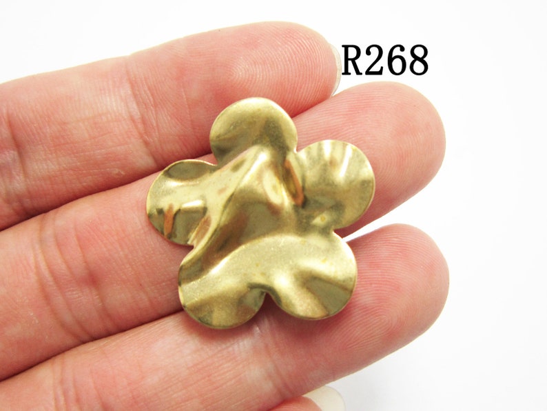 K&ouml;nnte beinhalten: Goldfarbener Metall-Blumenanh&auml;nger mit texturierter, wellenf&ouml;rmiger Oberfl&auml;che. R268.