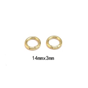 Pode incluir: Duas fivelas circulares douradas com abertura articulada. As fivelas t&ecirc;m 1,4 cm de di&acirc;metro e 3 mm de espessura. Em fundo branco.