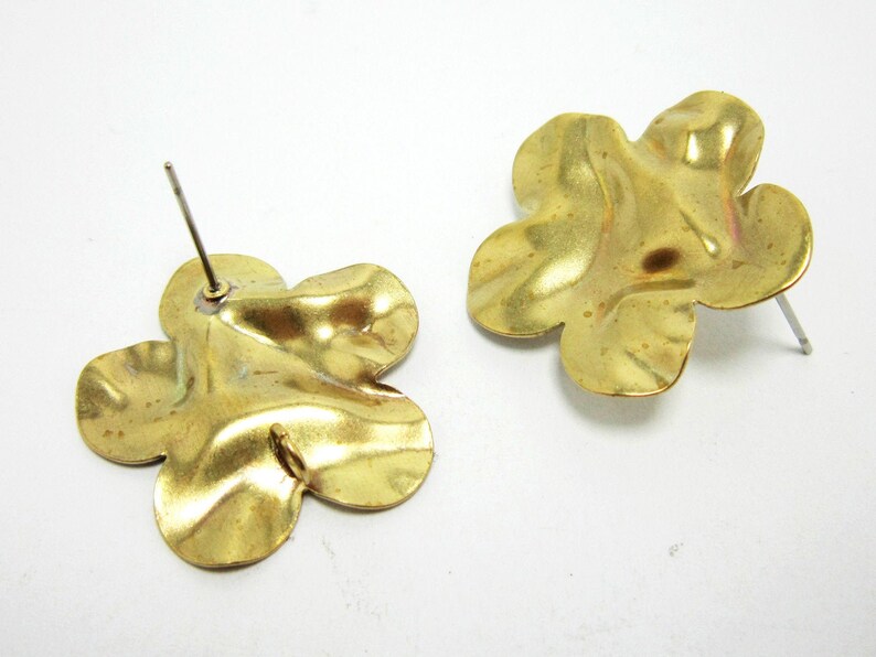 K&ouml;nnte beinhalten: Ein Paar goldfarbene, blumenf&ouml;rmige Ohrringe mit strukturierter Oberfl&auml;che. Die Ohrringe haben einen Stiftverschluss.