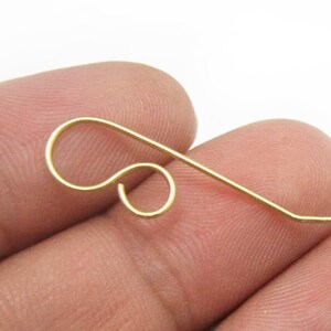 May include: Gold-toned earring hook with a loop at the top and a straight wire extending from the loop.