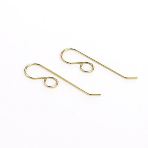 May include: Two gold-toned earring hooks, each with a small loop at the top and a longer, slightly curved wire extending from the loop.