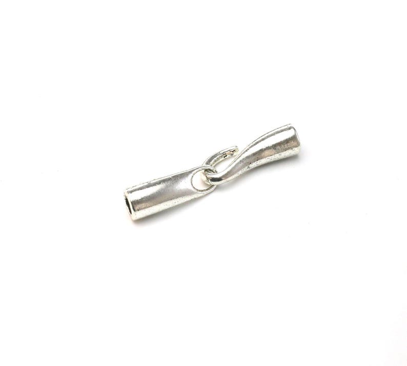 May include: Silver-toned metal clasp with a loop on one end and a barrel-shaped connector on the other end.