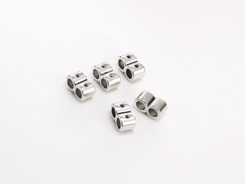 May include: Silver-toned metal clasps for jewelry making. Each clasp has two loops for attaching chains or cords.