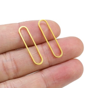May include: Two gold oval-shaped earring findings.