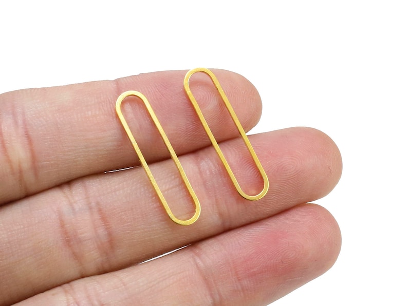 May include: Two gold oval-shaped earring findings.