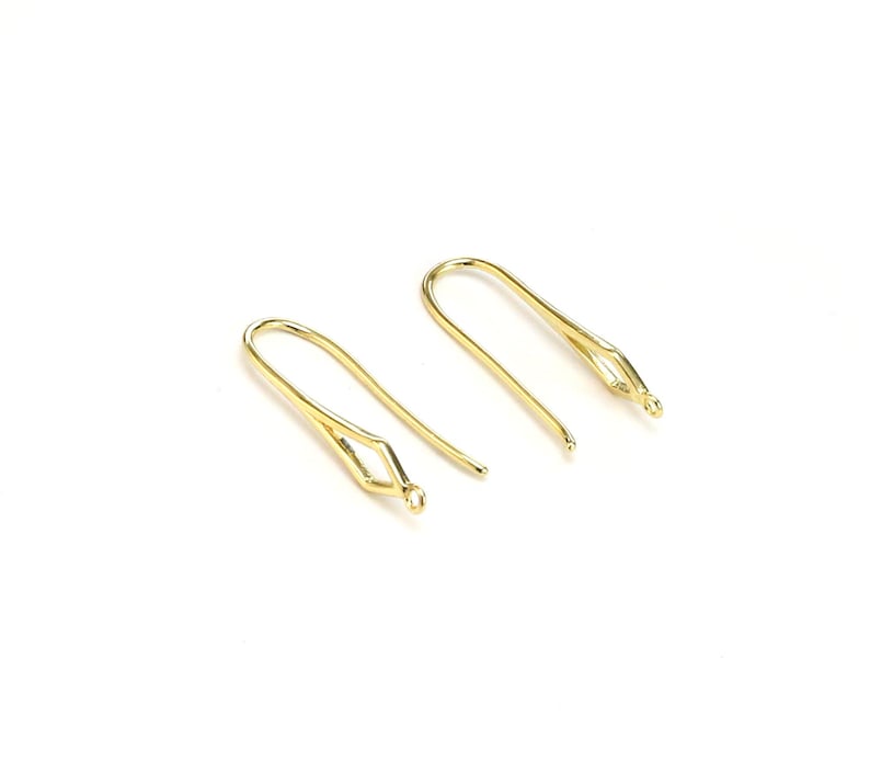 May include: Two gold-toned earring hooks with a loop at the top and a small opening at the bottom.