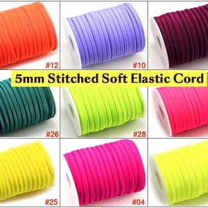 Può includere: Assortimento di cordoncino elastico morbido cucito da 5 mm in vari colori, tra cui arancione, viola, bordeaux, verde, giallo, rosa e giallo fluo. Il cordoncino è avvolto su bobine con le etichette #12, #10, #15, #26, #28, #27, #25, #04 e #30.