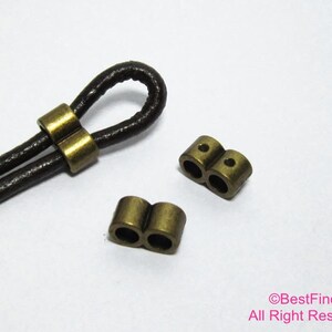 May include: Two gold-toned metal cord end caps with two holes each. The cord end caps are designed to be used with leather cord.