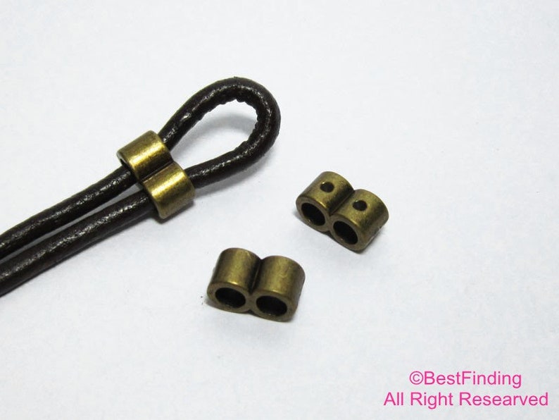 May include: Two gold-toned metal cord end caps with two holes each. The cord end caps are designed to be used with leather cord.